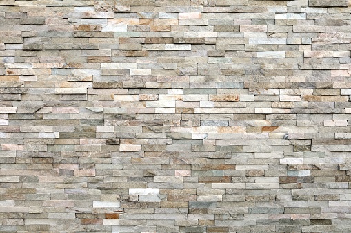 external wall covering made of brick stones of different colors. full frame.
